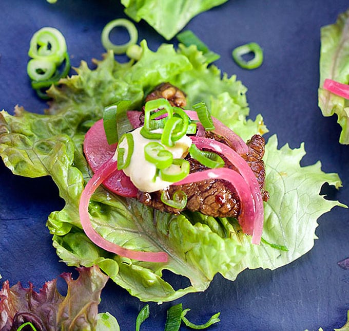 These Korean Beef Lettuce Wraps are an explosion of flavor. Famously delicious Korean Bulgogi beef wrapped up in lettuce leaves with homemade picked onions and radishes and miso mayonnaise. Serve as an appetizer or main dish l Panning The Globe Recipe