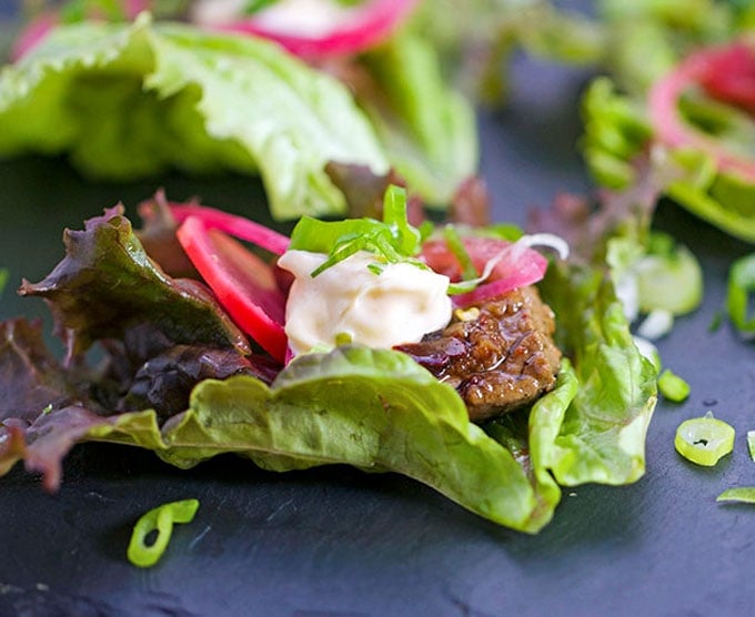 These Korean Beef Lettuce Wraps are an explosion of flavor. Famously delicious Korean Bulgogi beef wrapped up in lettuce leaves with homemade picked onions and radishes and miso mayonnaise. Serve as an appetizer or main dish l Panning The Globe Recipe