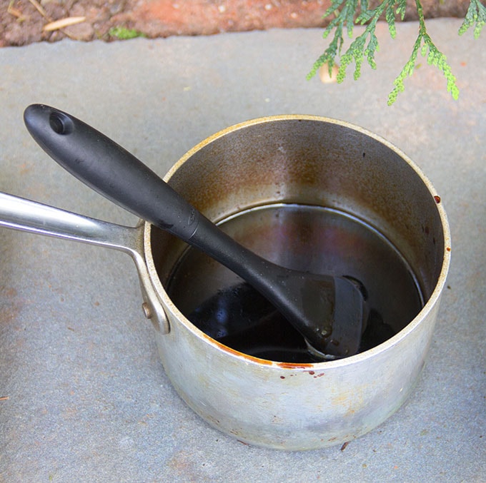 Yakitori sauce in a saucepan with a pastry brush in the pot, for glazing the chicken as it grills