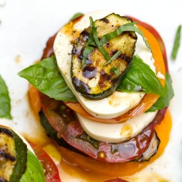 Here's a delicious and fun twist on the classic Italian Caprese Salad recipe. Grilled zucchini is added to the mix and everything is arranged in stacks. It's an easy appetizer recipe that looks elegant. Or serve it for lunch or brunch l www.panningtheglobe.com  