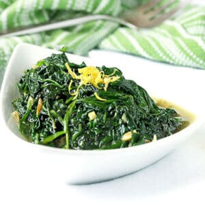 sautéed spinach in a bowl, topped with lemon zest.
