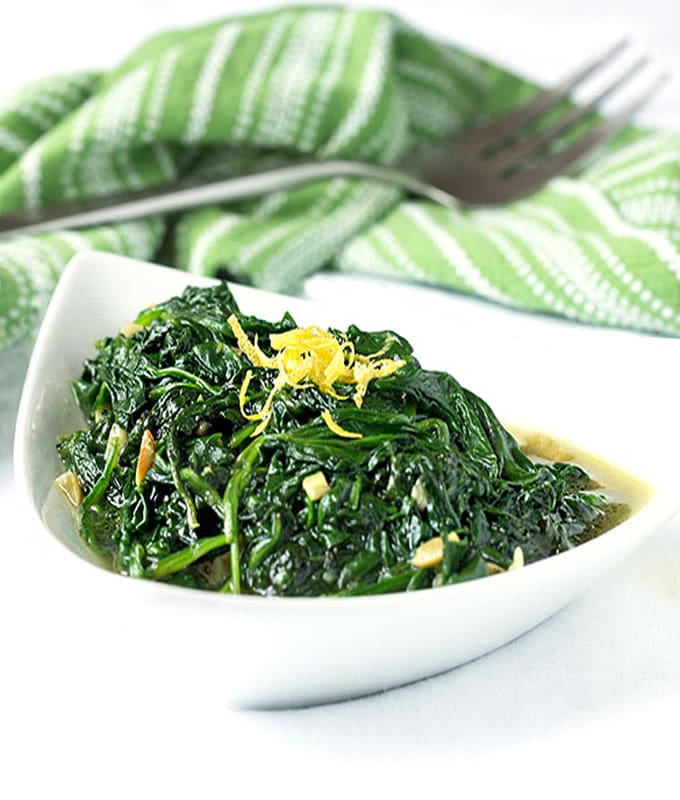 Sautéed Spinach and Garlic in a bowl topped with lemon zest.