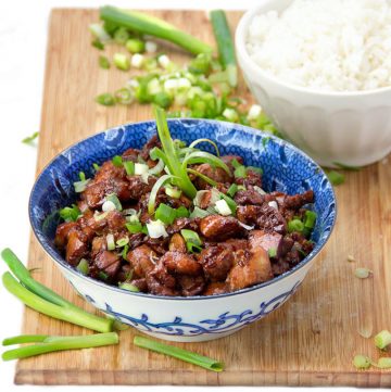 Asian honey soy chicken in a bowl sprinkled with scallions.