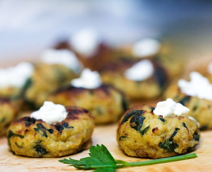 Mini Spinach Potato Knish Appetizer topped with sour cream. 