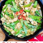 pinterest pin: thai green curry chicken in a cast iron skillet with sliced red peppers in the middle for garnish