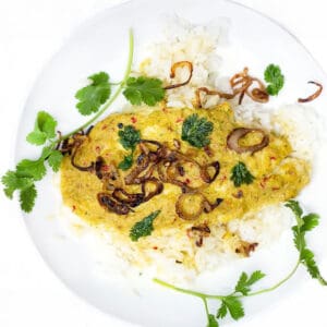 Thai steamed fish in coconut sauce topped with fried shallots and cilantro leaves.