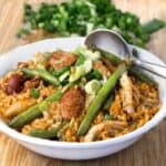 a bowl of spicy chicken jambalaya with sausages and green beans