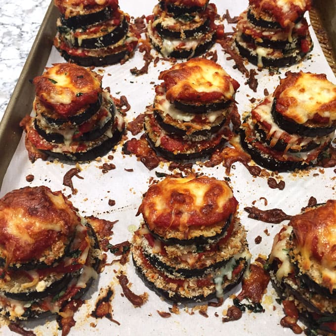 A rimmed baking sheet with 9 Eggplant Parmesan Stacks