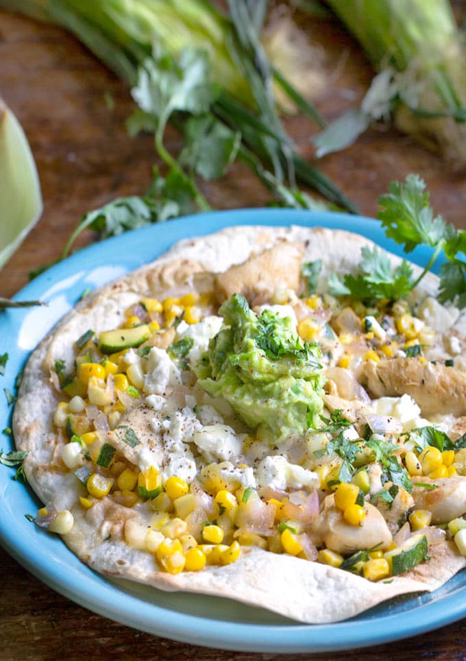 Tostada: flour tortilla topped with chicken, corn, zucchini, onions, feta and avocado salsa