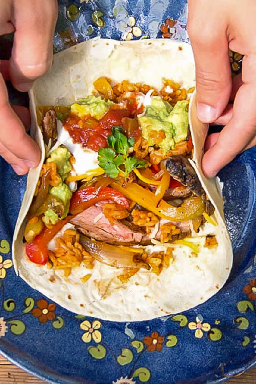 flour tortilla filled with grilled steak, salsa, guacamole, red rice, sour cream and sauteed peppers and onions.