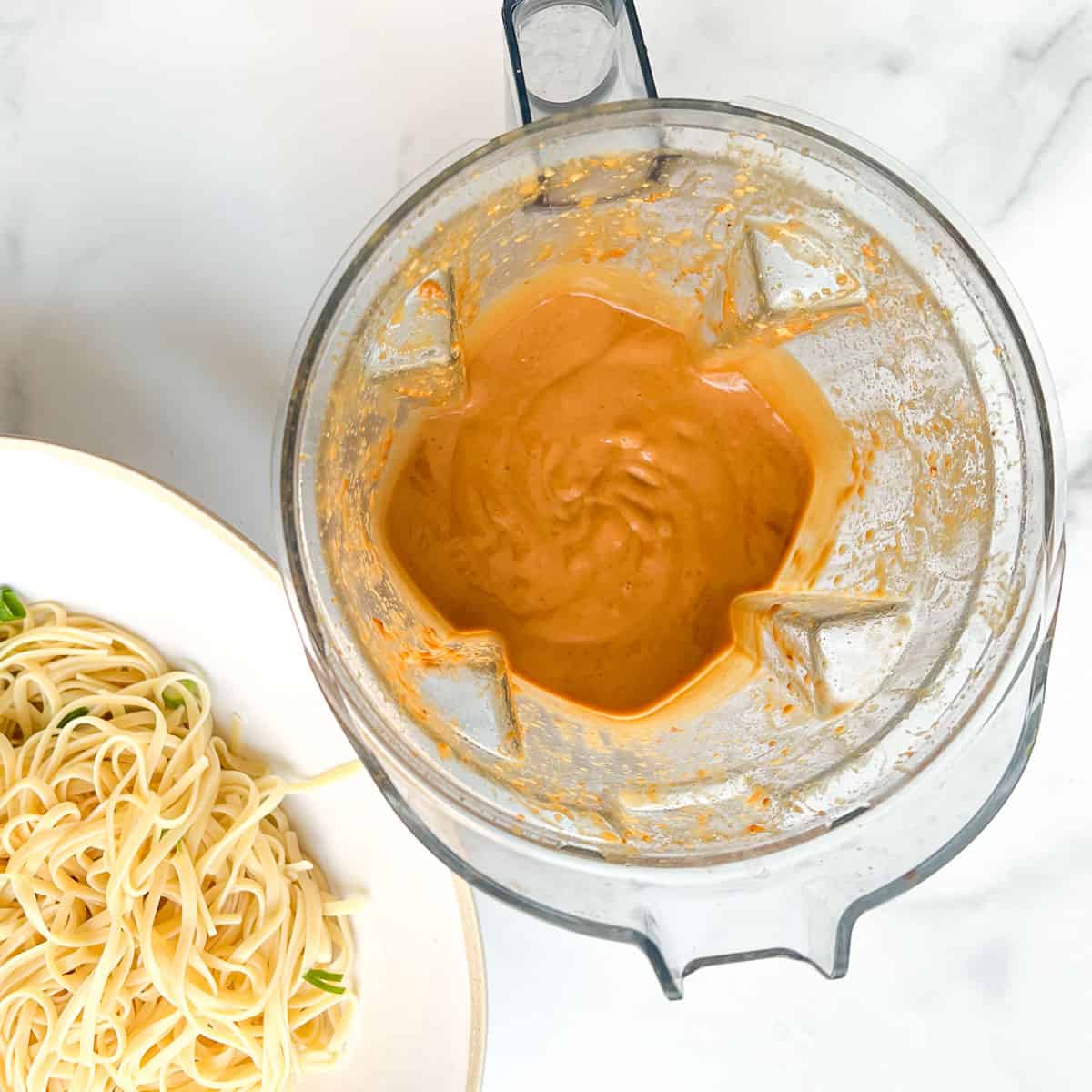 Looking down into a blender containing peanut sauce.