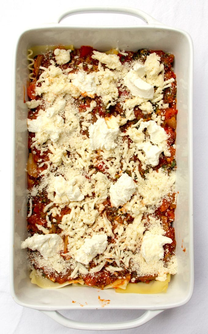 Roasted vegetable lasagna in a white rectangular casserole dish shown from above before it's been baked