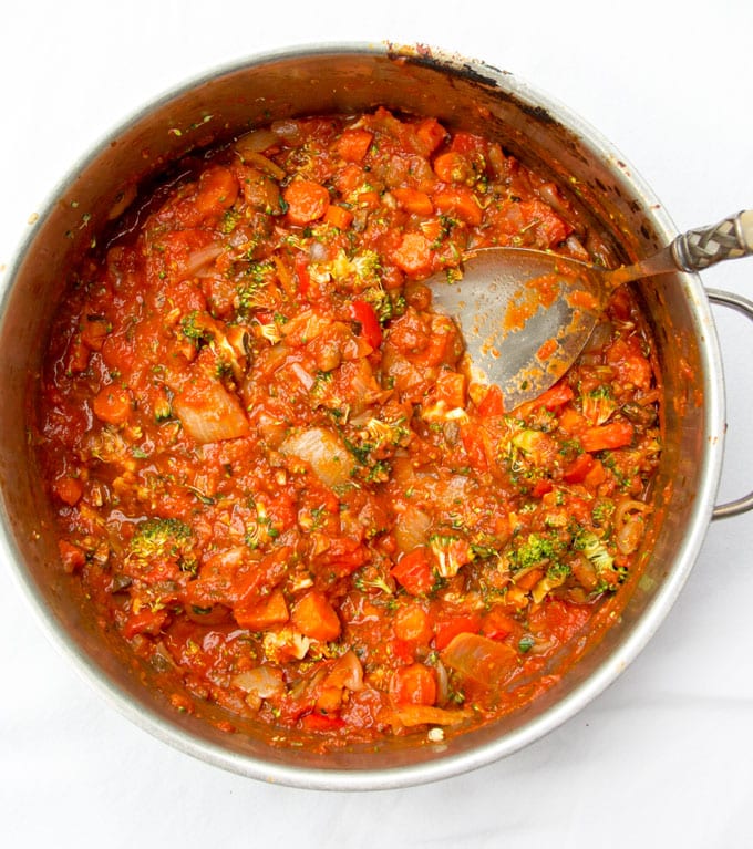 overhead view of a silver sauce pot filled with sauce for roasted vegetable lasagna