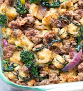 sausage stuffing with bits of broccoli rabe and red onion in a glass casserole