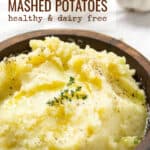 Pinterest Pin: olive oil and roasted garlic mashed potatoes in a brown wooden bowl with a sprig of thyme on top.