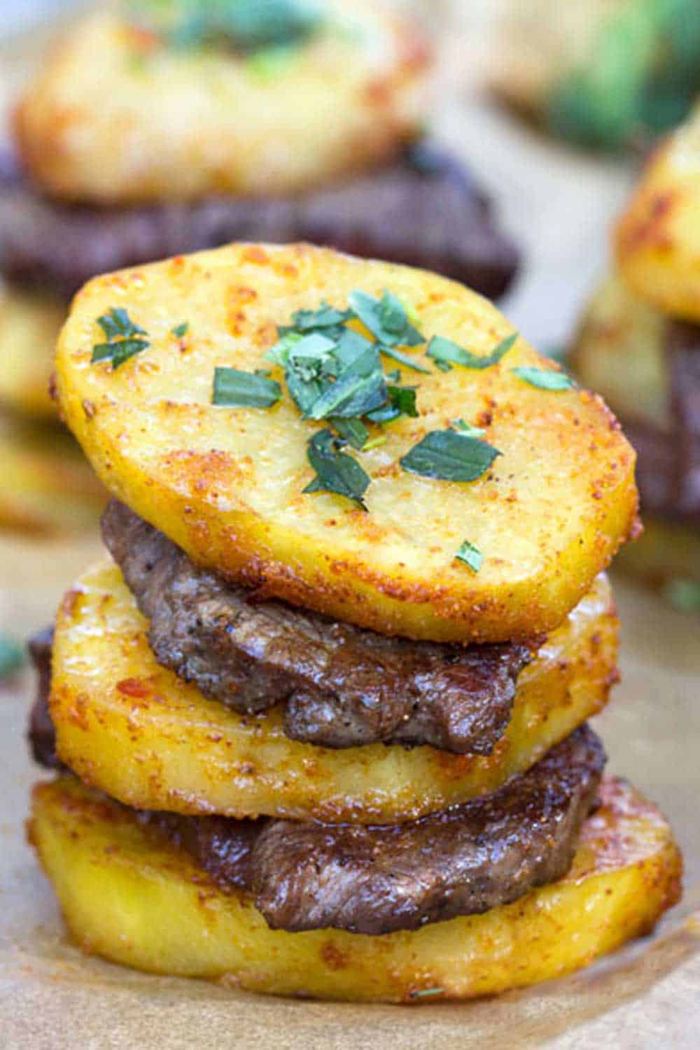 stack of steak and potatoes - three slices of roasted potatoes layered with two slices of beef tenderloin