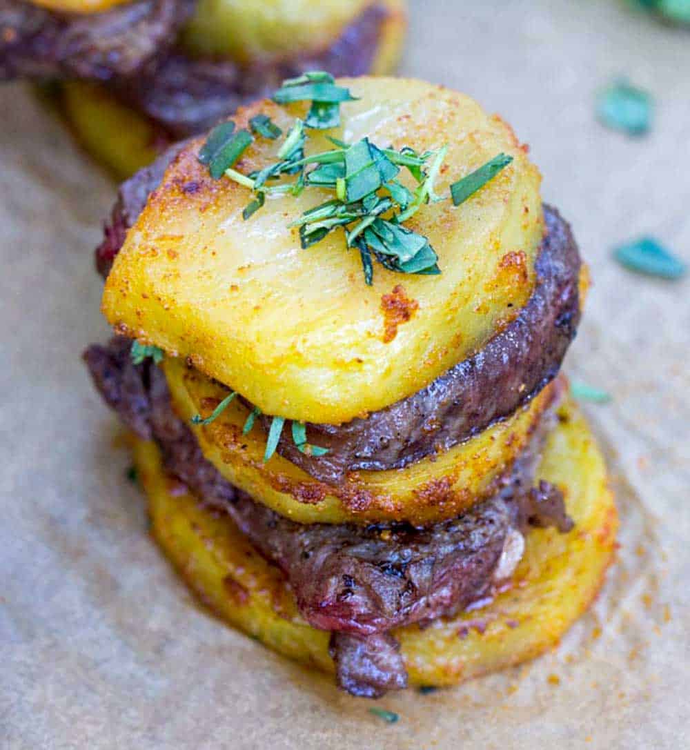 stack of steak and potatoes - three slices of roasted potatoes layered with two slices of beef tenderloin