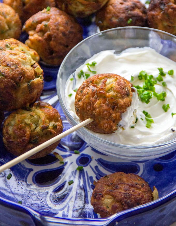 These Savory Potato Aebleskivers are potato pancakes like you've never had them before. The batter is made from tender red lentils, shredded potatoes, herbs and chilies. The pancakes are cooked in a special pan that forms them into golden brown spheres that are crisp on the outside, fluffy and tender inside. Serve these scrumptious bites as a party appetizer or a game day snack. As a bonus, these potato aebleskivers are gluten-free, dairy-free, and egg-free.