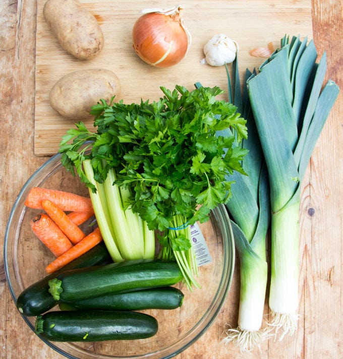 raw vegetables for minestrone soup: parsley, 4 zucchinis, two leeks, 5 carrots, a bunch of celery, two potatoes, an onion, a head of garlic