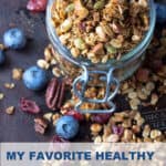 Pinterest Pin: granola in a glass jar surrounded by blueberries and dried cranberries
