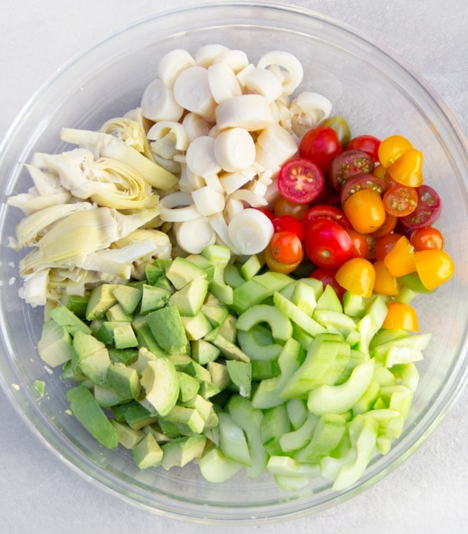 Ingredients for Brazilian hearts of palm salad: sliced hearts of palm, cucumbers, artichoke hearts, avocados and cherry tomatoes