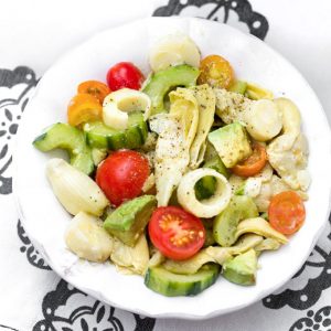 bowl with hearts of palm salad with cucumbers, artichoke hearts and cherry tomatoes