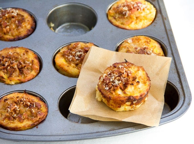 These savory cauliflower tarts are amazing little flavor bombs: potato-gruyere crusts filled with onions, garlic, cauliflower, eggs, cheese, and spices, topped with bacon and parmesan. A perfect recipe for a special brunch, with an easy vegetarian adaptation.