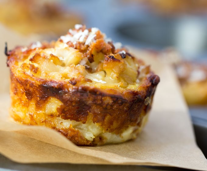 These savory cauliflower tarts are amazing little flavor bombs: potato-gruyere crusts filled with onions, garlic, cauliflower, eggs, cheese, and spices, topped with bacon and parmesan. A perfect recipe for a special brunch, with an easy vegetarian adaptation.