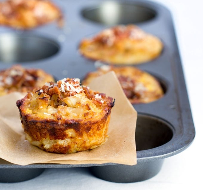 These savory cauliflower tarts are amazing little flavor bombs: potato-gruyere crusts filled with onions, garlic, cauliflower, eggs, cheese, and spices, topped with bacon and parmesan. A perfect recipe for a special brunch, with an easy vegetarian adaptation.