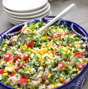 Colorful chopped salad in a blue oval bowl.