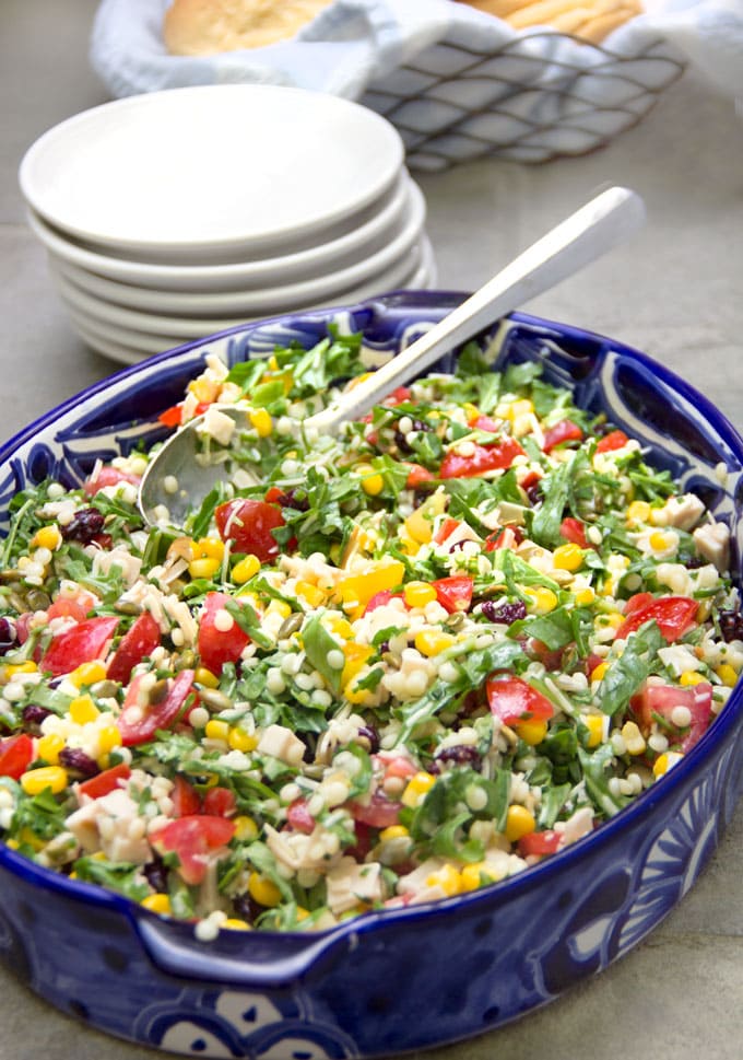 Colorful chopped salad in a blue oval bowl.