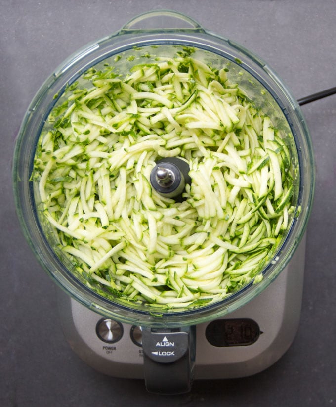 overhead view of food processor filled with freshly shredded zucchini