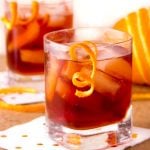 two deep red boulevardier cocktails with garnishes of swirly orange peel dangling from the glassThe Boulevardier is complex, refreshing and totally delicious - a fantastic drink recipe to add to your cocktail repertoire. With or without the smoke, these will be loved by all!