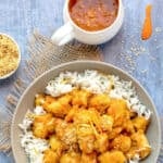 chinese orange chicken on a bed of rice in a bowl