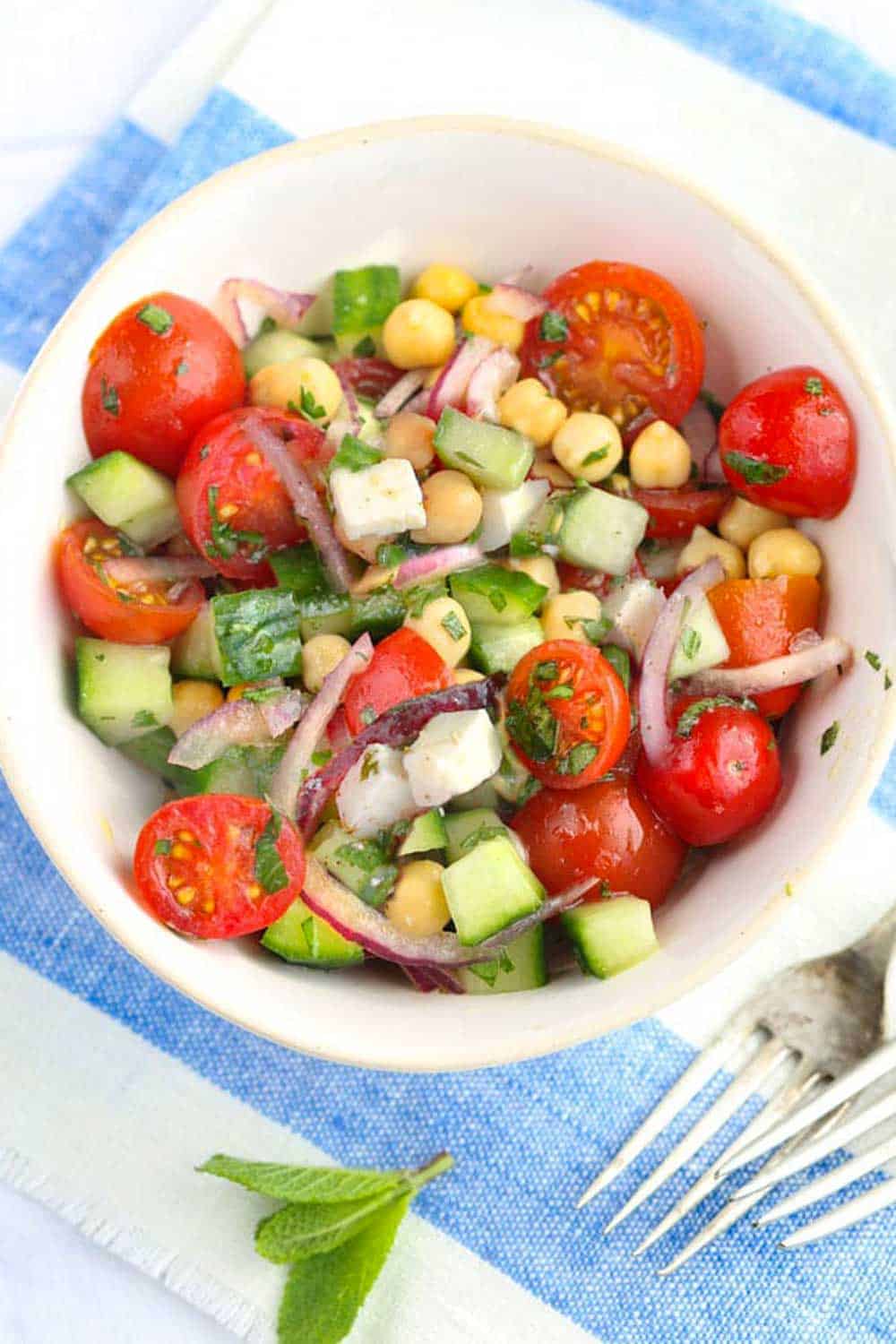 Mediterranean chickpea salad with cucumbers, feta, cherry tomatoes, herbs and lemony dressing