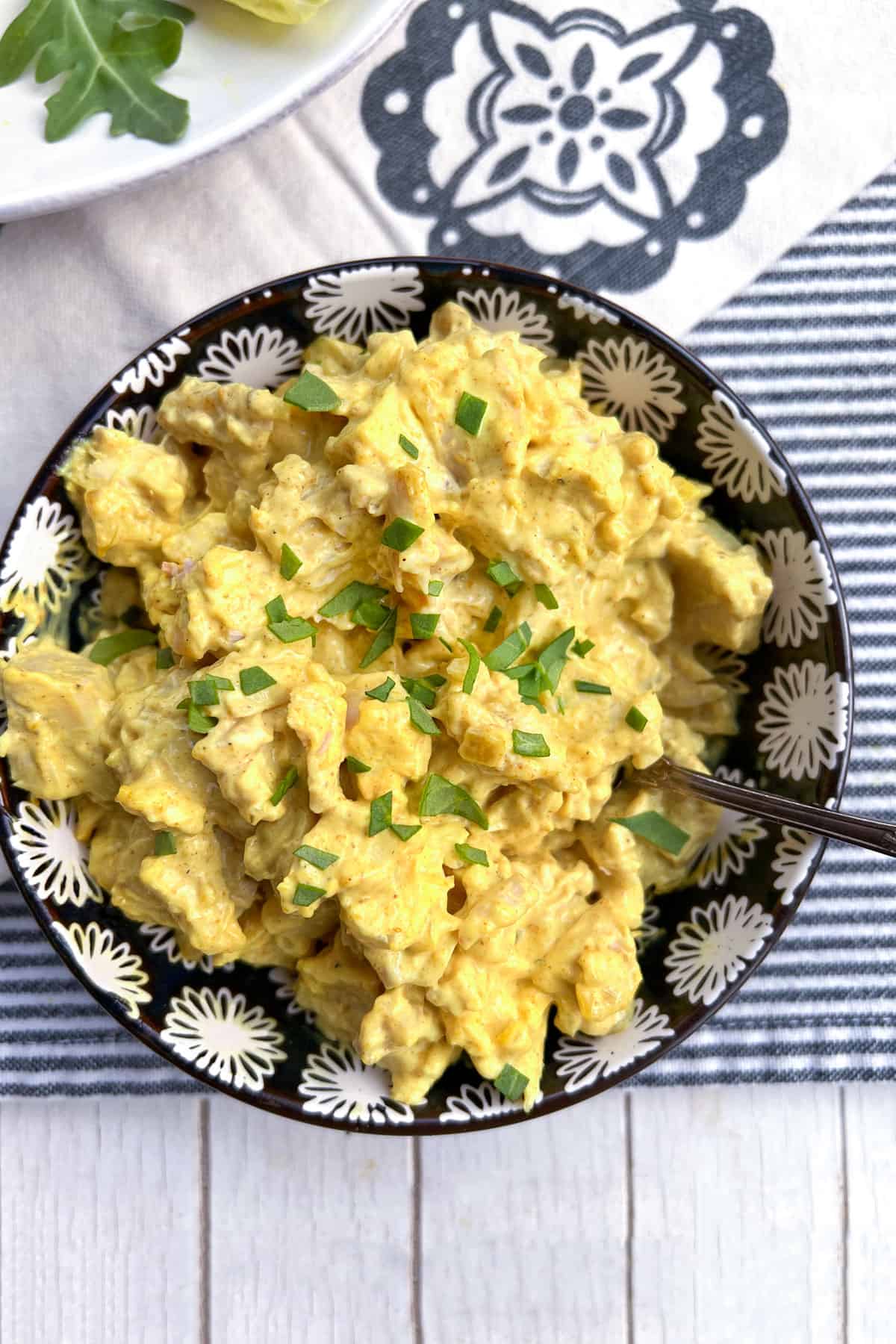 black and white flowered bowl filled with curried chicken salad