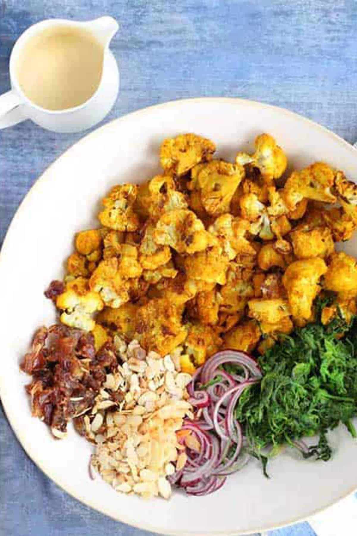 ingredients for turmeric roasted cauliflower salad, in a large bowl.