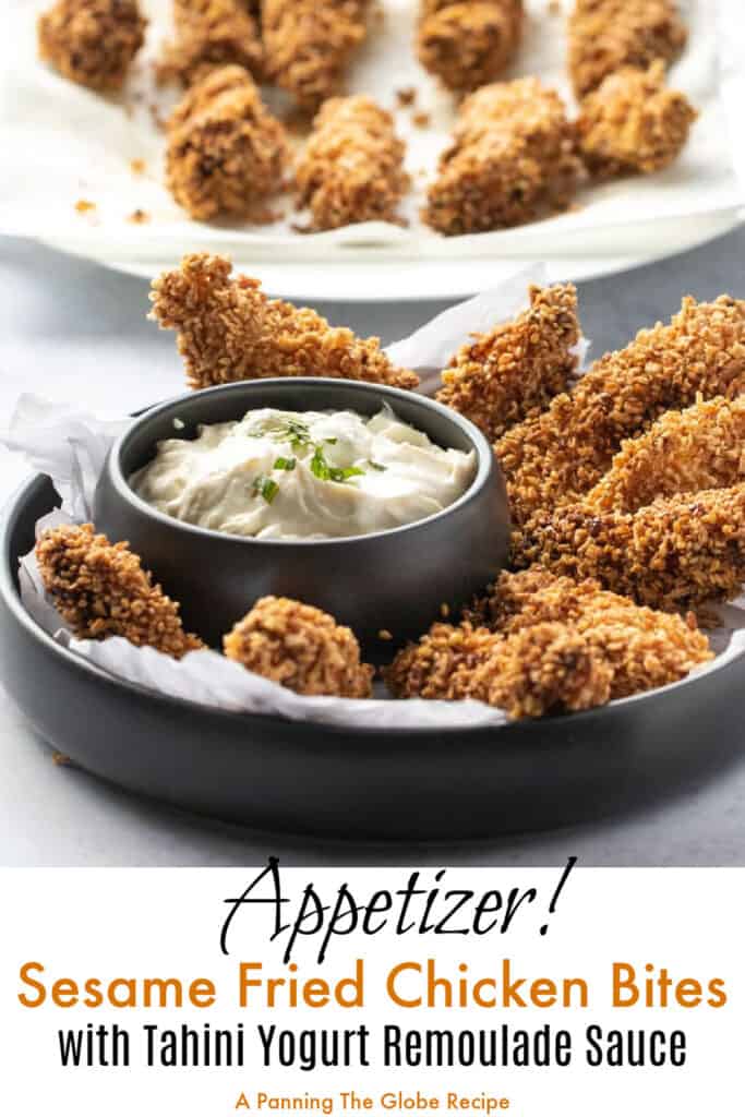 9 pieces of fried chicken fingers in a black bowl, with a small bowl of remoulade sauce to dip