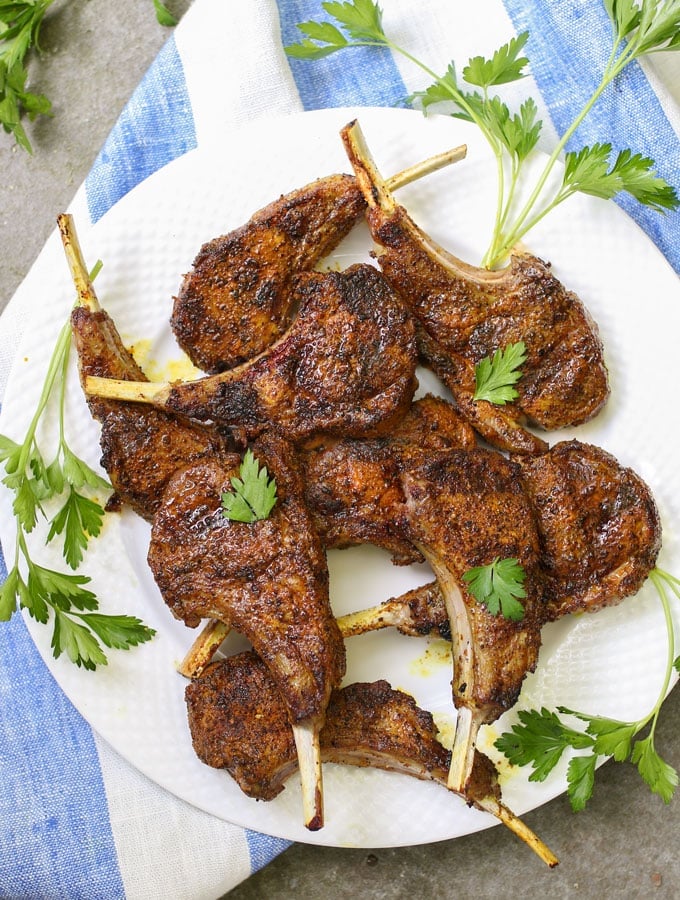 A plate of grilled lamb chops with parsley garnish