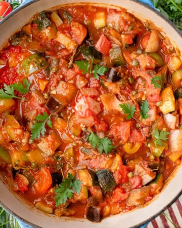 Dutch oven on a striped cloth, filled with ratatouille