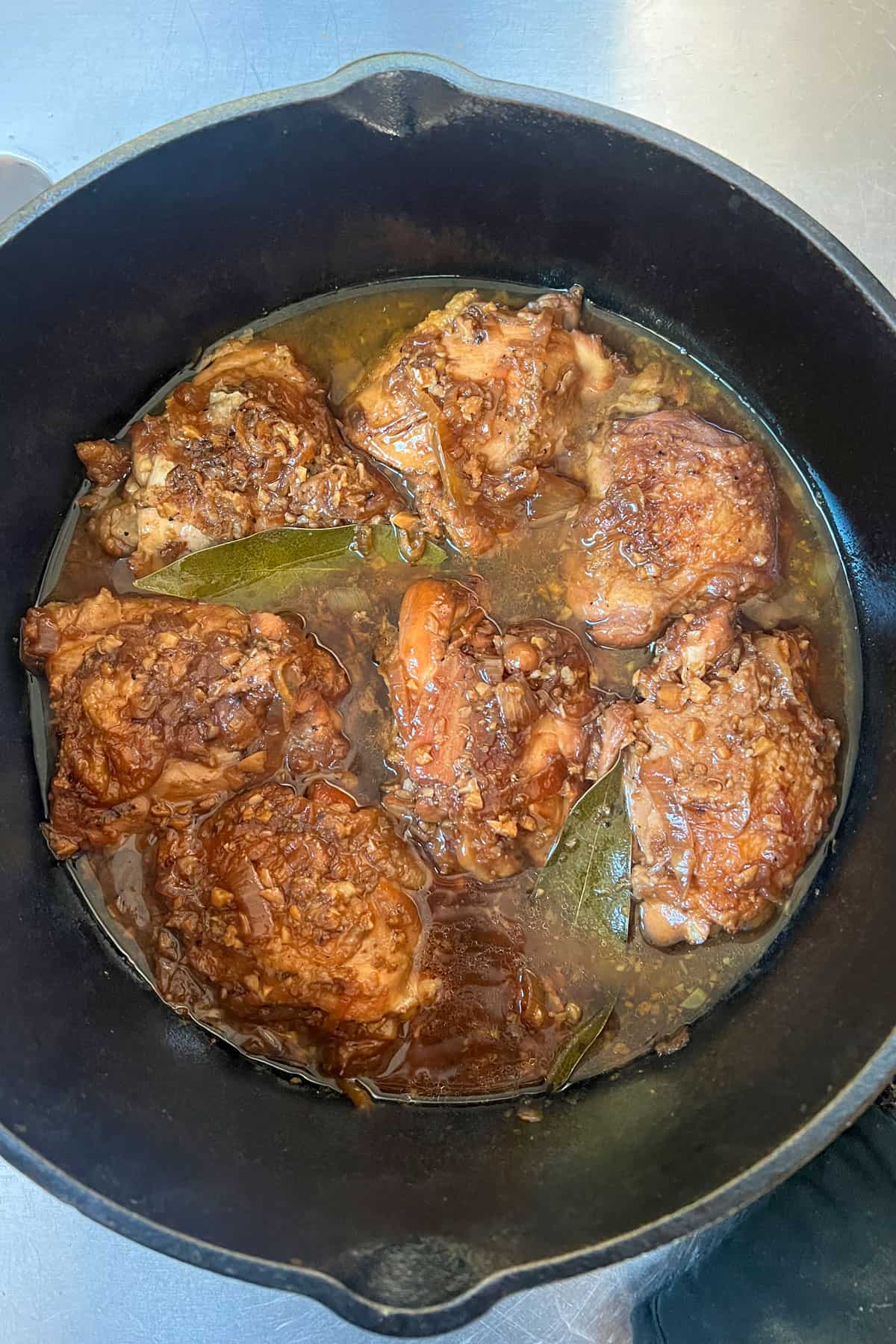 7 deep golden brown braised chicken thighs is a Dutch oven surround with a rich sauce.