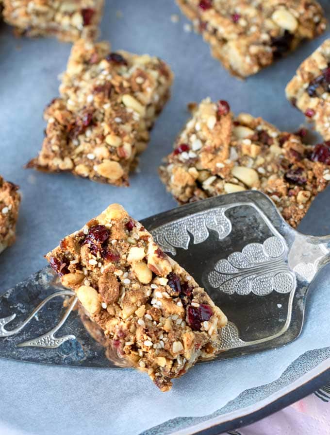 One fruit and nut bar on a fancy silver cake server with a few other bars in the background