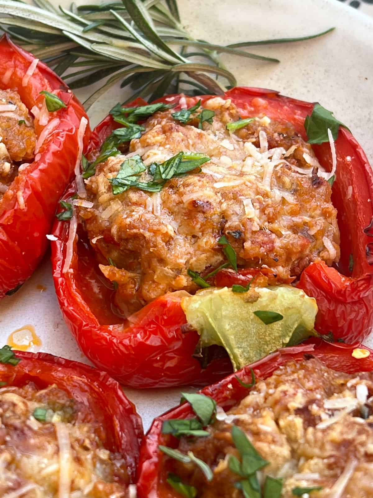 one cooked stuffed red bell pepper with melted parmesan cheees on top.