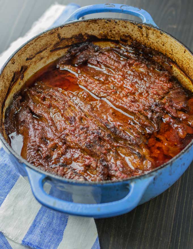 Blue Dutch oven shown from above filled with Nach Waxman's cooked sliced brisket