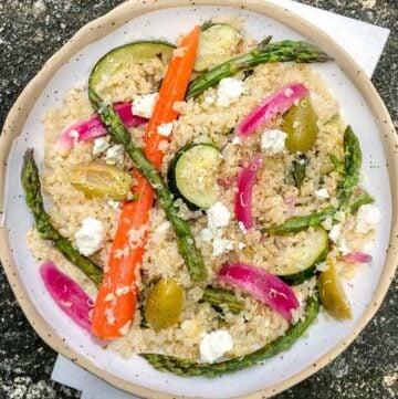 white bowl with quinoa and vegetables salad with feta