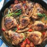 8 braised chicken thighs in a cast iron skillet with cherry tomatoes, shallots and tarragon