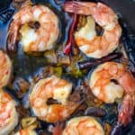 Close up of a cast iron skillet with 8 spicy garlic shrimp