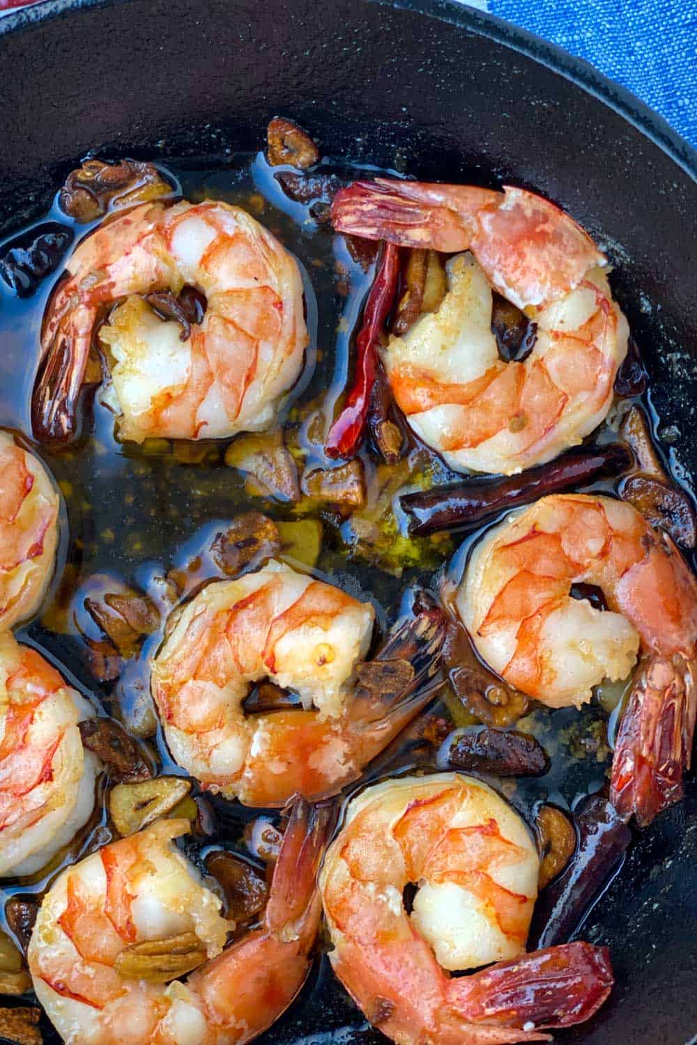 Close up of a cast iron skillet with 8 spicy garlic shrimp