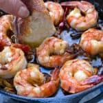 Close up of a cast iron skillet with 8 spicy garlic shrimp