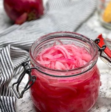 glass jar filled with pink pickled red onions.